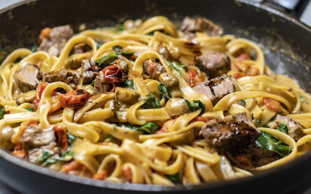 Mushroom pappardelle in a ceramic bowl on a wood table